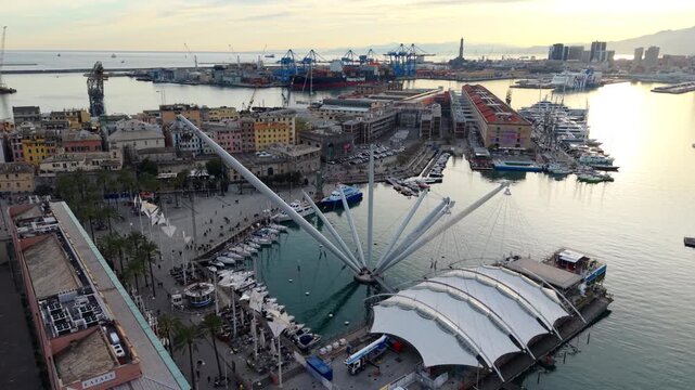 Counterclockwise drone orbit around Bigo crane in Porto Antico, Genoa at sunset, iconic architectural landmark located in old port area, Italy.
