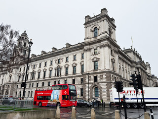 Obraz premium Red double decker bus passing a historic government building in Whitehall, London, UK
