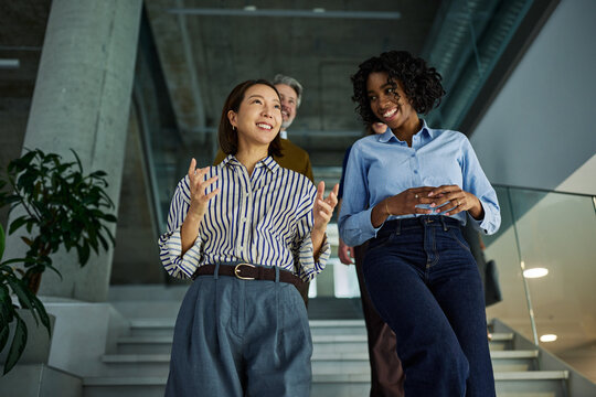 Happy diverse businesswomen having conversation in modern office