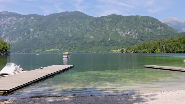 Wooden Pier and Motor Boat on Crystal Clear Lake Bohinj, Slovenia