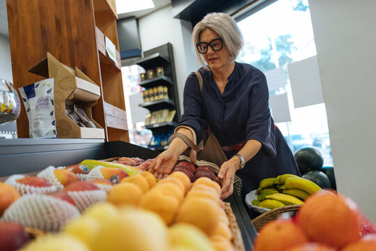 Senior woman choosing fresh groceries in market