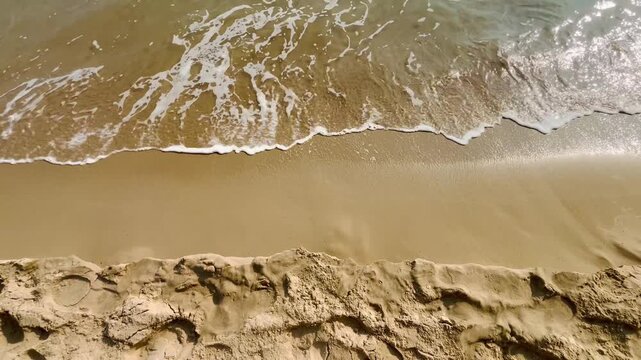 Soft waves on sandy shoreline beach