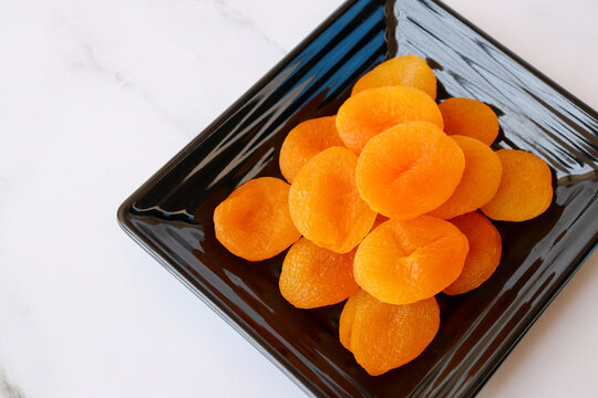 Dried apricots isolated on white background with copy space. Sun-dried golden organic apricots, natural healthy snack rich in nutrients, vibrant color and texture, ideal for food concepts.