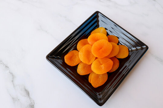 Dried apricots isolated on white background with copy space. Sun-dried golden organic apricots, natural healthy snack rich in nutrients, vibrant color and texture, ideal for food concepts.