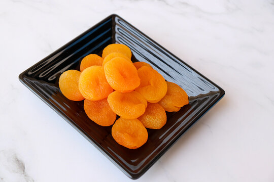 Dried apricots isolated on white background with copy space. Sun-dried golden organic apricots, natural healthy snack rich in nutrients, vibrant color and texture, ideal for food concepts.