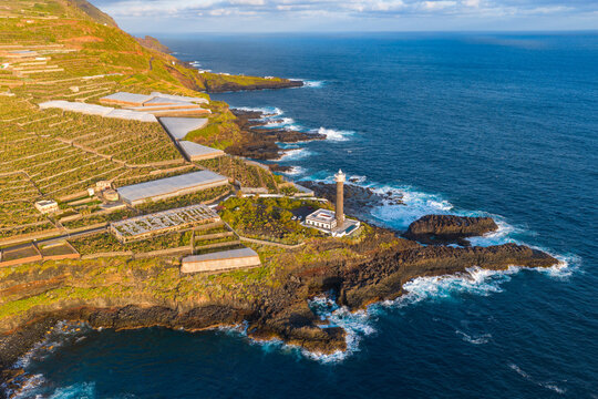 Aerial View of La Fajana Lighthouse and Coastal Banana Plantations at Sunrise; Maritime Infrastructure, Industrial Agriculture, and Solar Azimuth, La Palma, Canary Islands, Spain