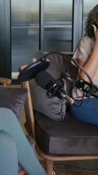 Vertical video: Talking host mint top gesturing in studio, recording starting near mic, copy space