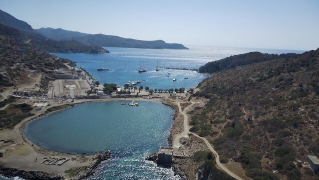 Aerial drone view of Knidos Ancient City in Dat&ccedil;a, surrounded by deep blue and turquoise shades of the Aegean Sea, ancient ruins on a dramatic peninsula, crystal-clear water, cinematic wide angle, ser