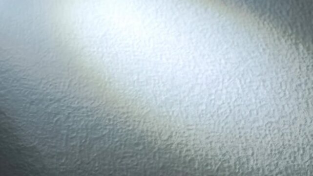 Static close up of frosted glass surface with shifting light and soft shadows on interior wall window partition