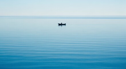 Fototapeta premium A small boat floats peacefully on the calm ocean water under a serene sky
