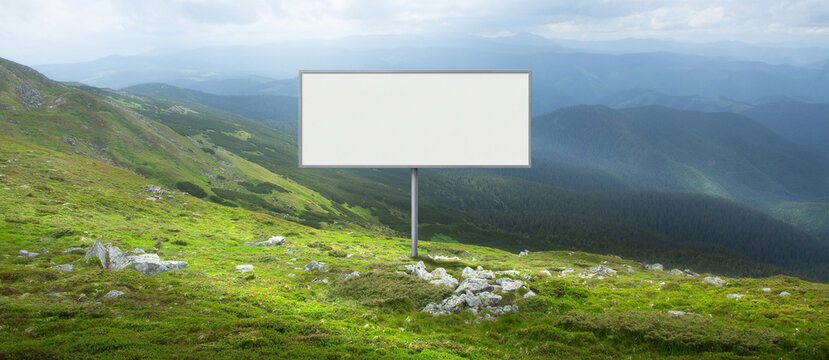 Outdoor billboard mockup in green mountain valley with wide copy space. Concept of advertising template, eco branding, campaign visualization and marketing presentation.