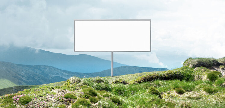 Clean billboard mockup in mountain meadow with bright sky copy space. Concept of minimal advertising template, brand presentation, fresh campaign design and outdoor marketing.
