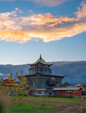 Vibrant Datsan monastery building under a colorful sky during evening light in a rural setting