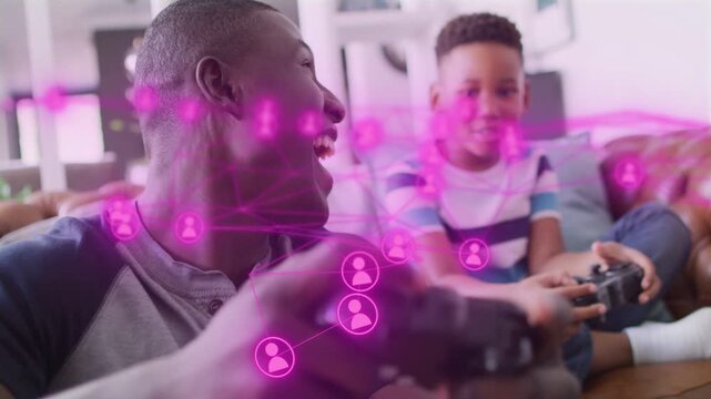 Vertical video: Dad and son on couch gaming, pressing gamepad causing pink HUD, son matching smiles