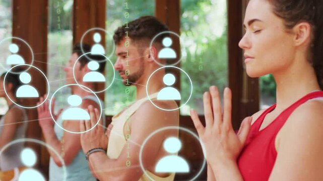 Group praying in yoga studio center icon starting expanding user icons showing binary over hands