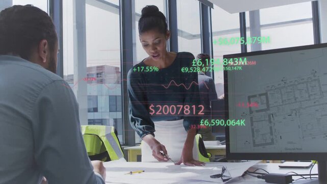 Standing presenter leaning and marking plans, activating finance overlays tying design to budget