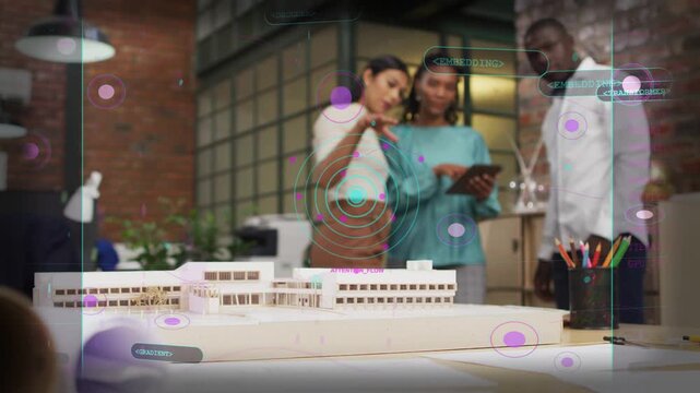 Design team pointing at model, scrolling tablet causing AR overlays marking hotspots for review