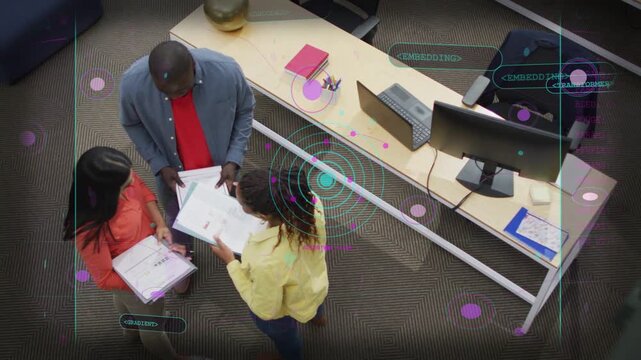 Yellow-top woman flipping pages, pointing, initiating office review while HUD showing binder labels