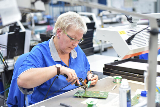 friendly woman working in a microelectronics manufacturing factory - component assembly and soldering