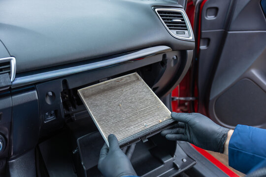 Replacing cabin air filter inside car dashboard during vehicle maintenance and cleaning