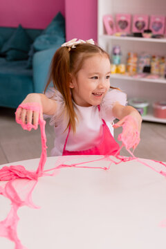 Little girl playing with slime indoors, creative sensory activity for children
