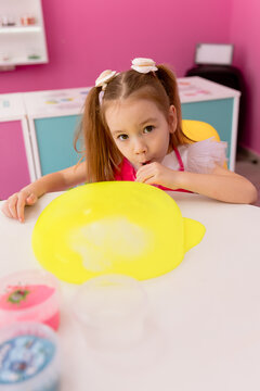 Little girl playing with slime indoors, creative sensory activity for children