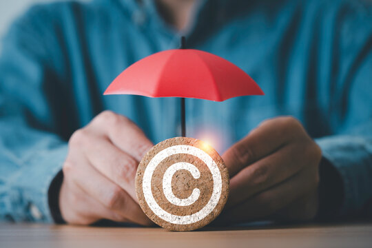 Copyright protection concept with umbrella shielding copyright symbol, represent intellectual property rights, legal protection, data security, ownership, licensing, and safeguarding creative assets