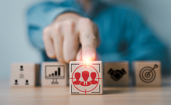 Customer focus concept with hand selecting target audience icon, representing market segmentation, customer acquisition strategy, audience analysis, digital marketing, and data driven business growth