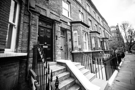 LONDON - Black and white Chelsea townhouses with steps and railings on classic residential street