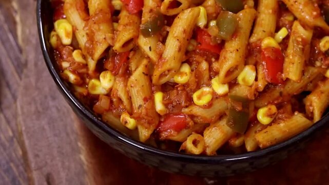 Penne Pasta cooked in tomato sauce with vegetables served in closeup. Perfect pasta, italian and meal visuals with rich texture and fresh presentation.