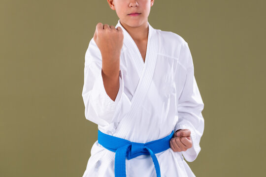 Toung karate student adjusting his sleeve and preparing his hands for a technique. Focus on discipline, precision, and readiness in martial arts training.