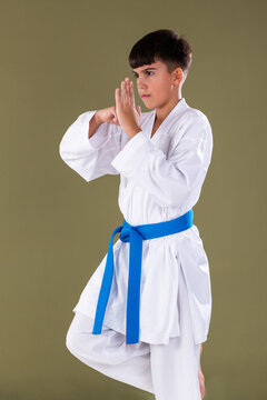 Karate student holds a one leg balance stance with hands aligned in a defensive position, showing coordination and stability.