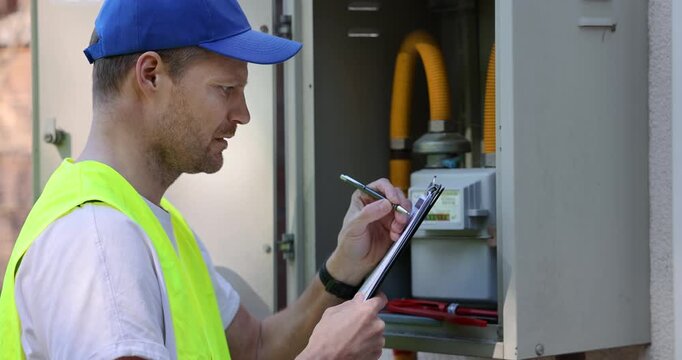 Gas meter inspection and maintenance. Worker writing documents