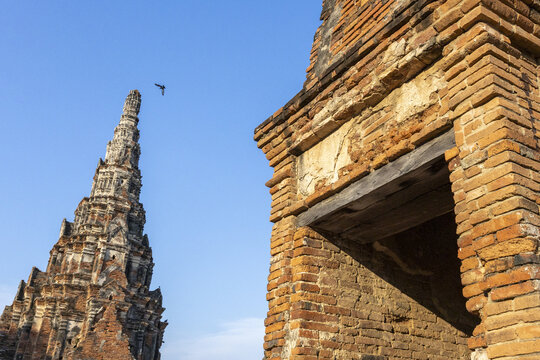Ancient temple ruins in Ayutthaya Thailand showing historic brick architecture under clear blue sky evoking sense of peaceful contemplation and wonder at majestic cultural heritage