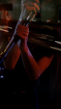 Vertical video: Pan to singer holding retro mic, singing to perform, lights streaking across face