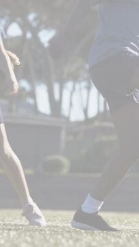 Vertical video: Two youth vying for soccer ball, causing motion line, securing control pushing away