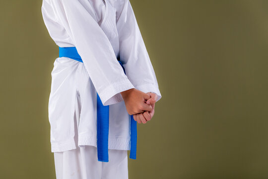 Karate boy stands in ready stance ,yoi , showing proper hand placement and posture before starting a technique.