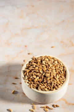 Farro in a white ceramic bowl on a marble surface 