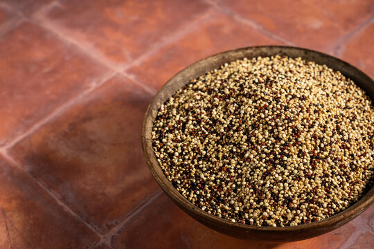 Rainbow, multi-colored quinoa on a tile surface 