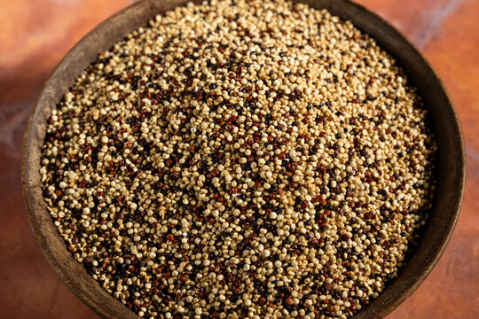 Rainbow, multi-colored quinoa on a tile surface 