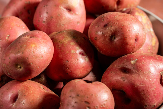 Red skin potatoes in a white ceramic bowl on a tole surface 