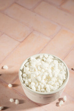 Pearl sugar in a white ceramic bowl on a tile surface 