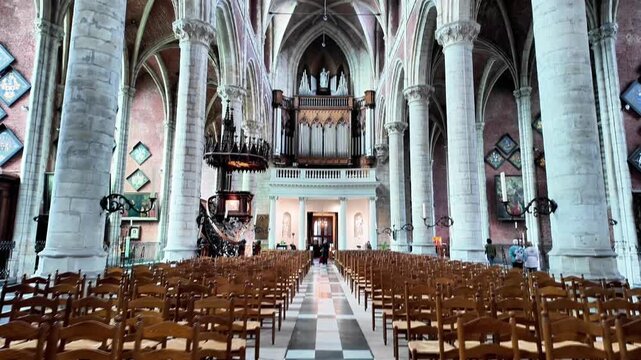 Wide interior view of a historic church in Ghent with an ornate pulpit and organ.