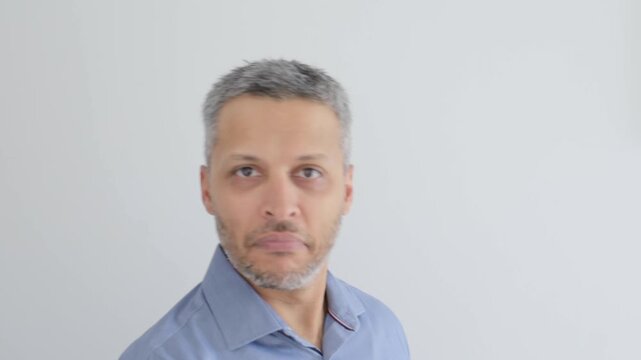 Mature man pointing at camera and nodding head with a serious expression