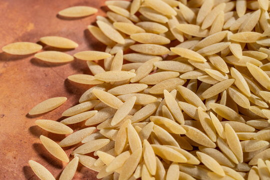Close up of uncooked orzo pasta on a tile surface 