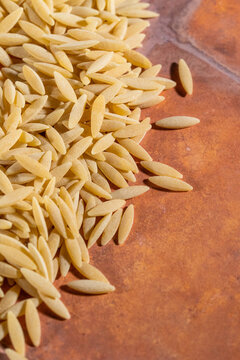 Close up of uncooked orzo pasta on a tile surface 