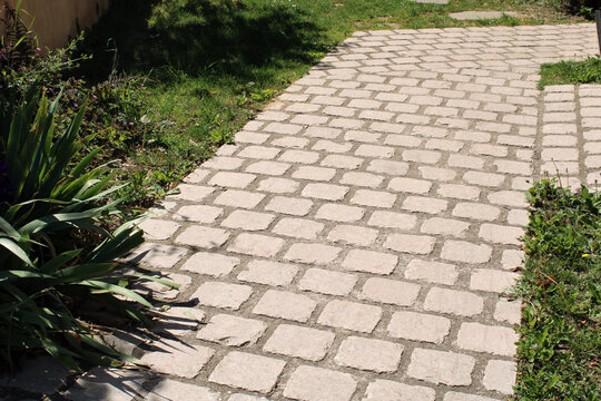 Chemin en pav&eacute;s, dallage carr&eacute;s ancien beige clair dans le jardin devant la maison