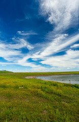 Obraz premium Hulunbuir Manzhouli Erka National Wetland Park: An Ecological Canvas of Blue Water, Sky, and Lush Green Grass