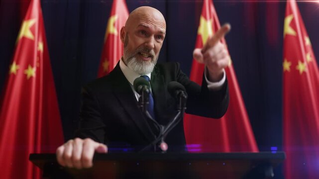 Irritated male politician delivering stern speech with China flags behind him