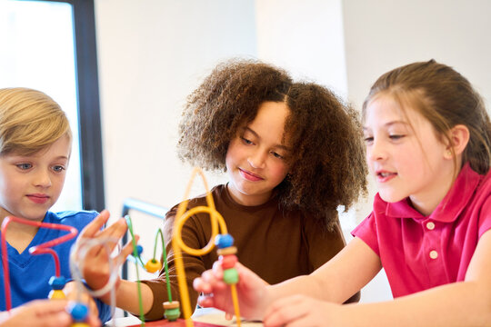 Children engaging in motor skills training with bead maze toys, pediatric physiotherapy session, rehabilitation exercises for kids, pediatric rehab center, balance training, physical therapy